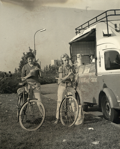 605189 Afbeelding van twee meisjes die een ijsje eten bij een ijscoman annex snackwagen, vermoedelijk in het plantsoen ...